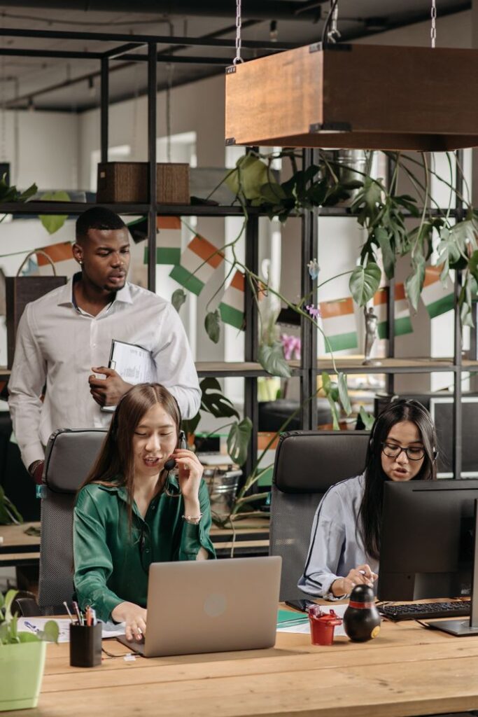 Crafting Captivating Headlines: Your awesome post title goes here Colleagues in an office setting collaborating on tasks with technology and decor around them.